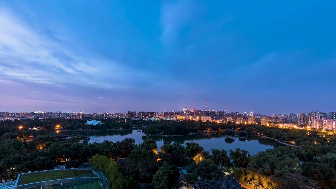 穿过北京龙潭湖望CBD日转夜风云变幻视频素材