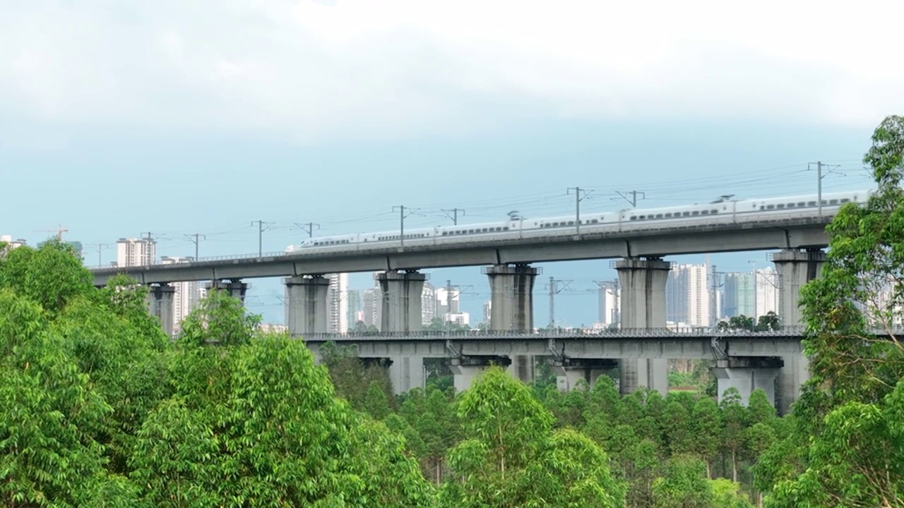 蓝天白云下城市中铁路桥上行驶的高铁动车视频素材