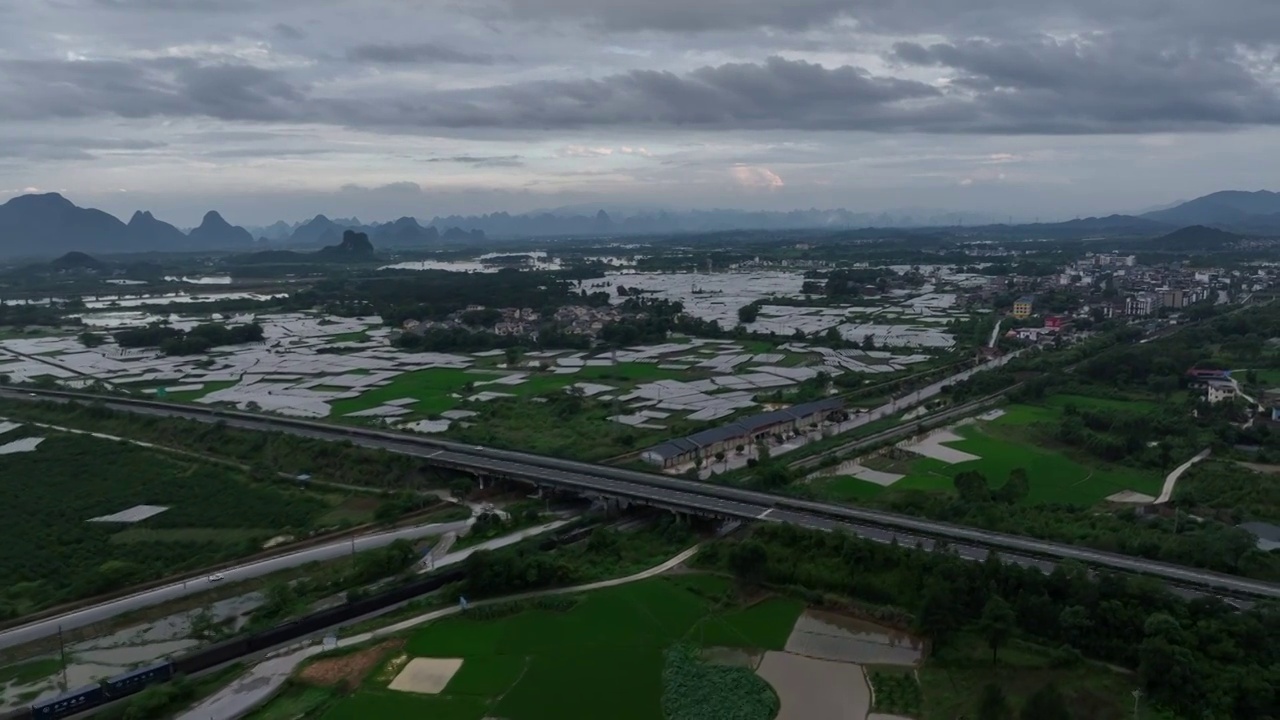 傍晚穿过村庄田地的铁路上行驶的货运列车视频素材