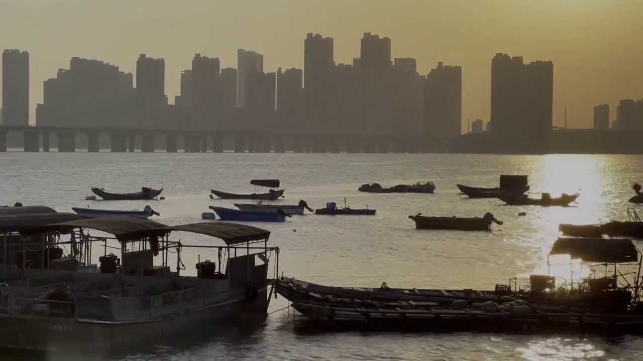 厦门集美黄昏，海上夕阳下的渔船运镜视频素材