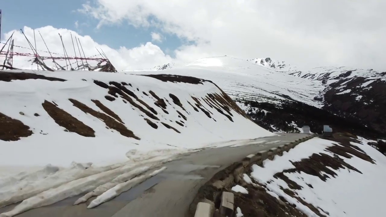 雪山顶沿着蜿蜒公路复杂飞行视频素材