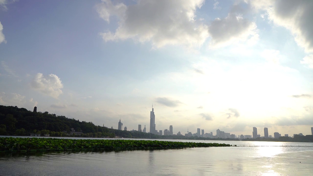 逆光下的南京玄武湖公园和城市上空流动的云景视频素材