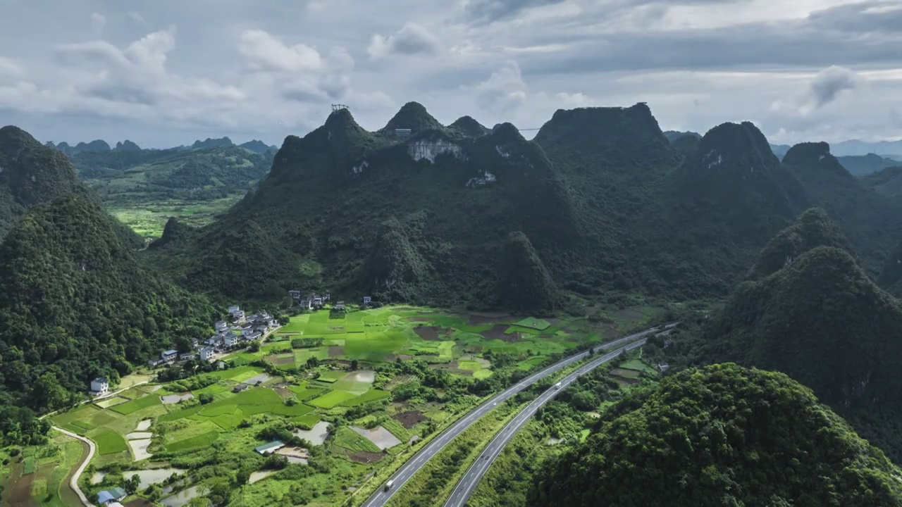 蓝天白云阳光下喀斯特地貌峰林中穿行的高速公路视频素材