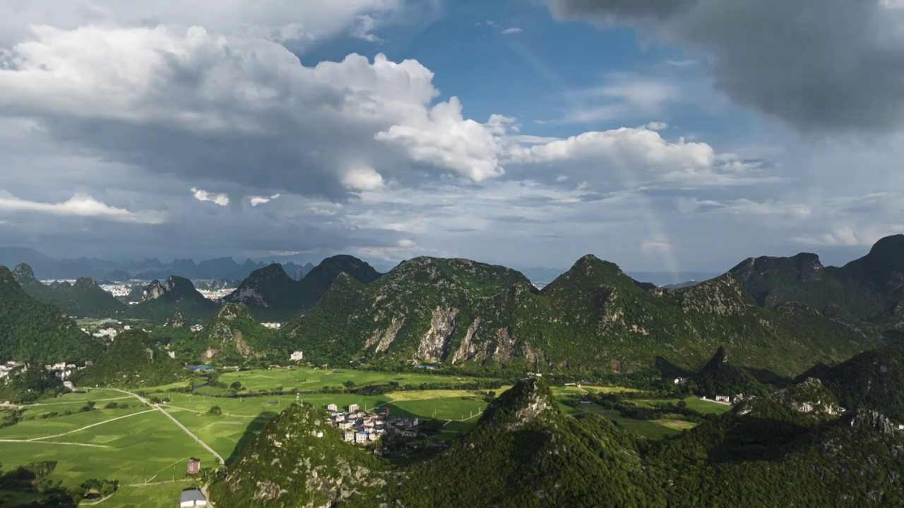 雨后天晴天空的彩虹下山谷中的田园风光视频素材