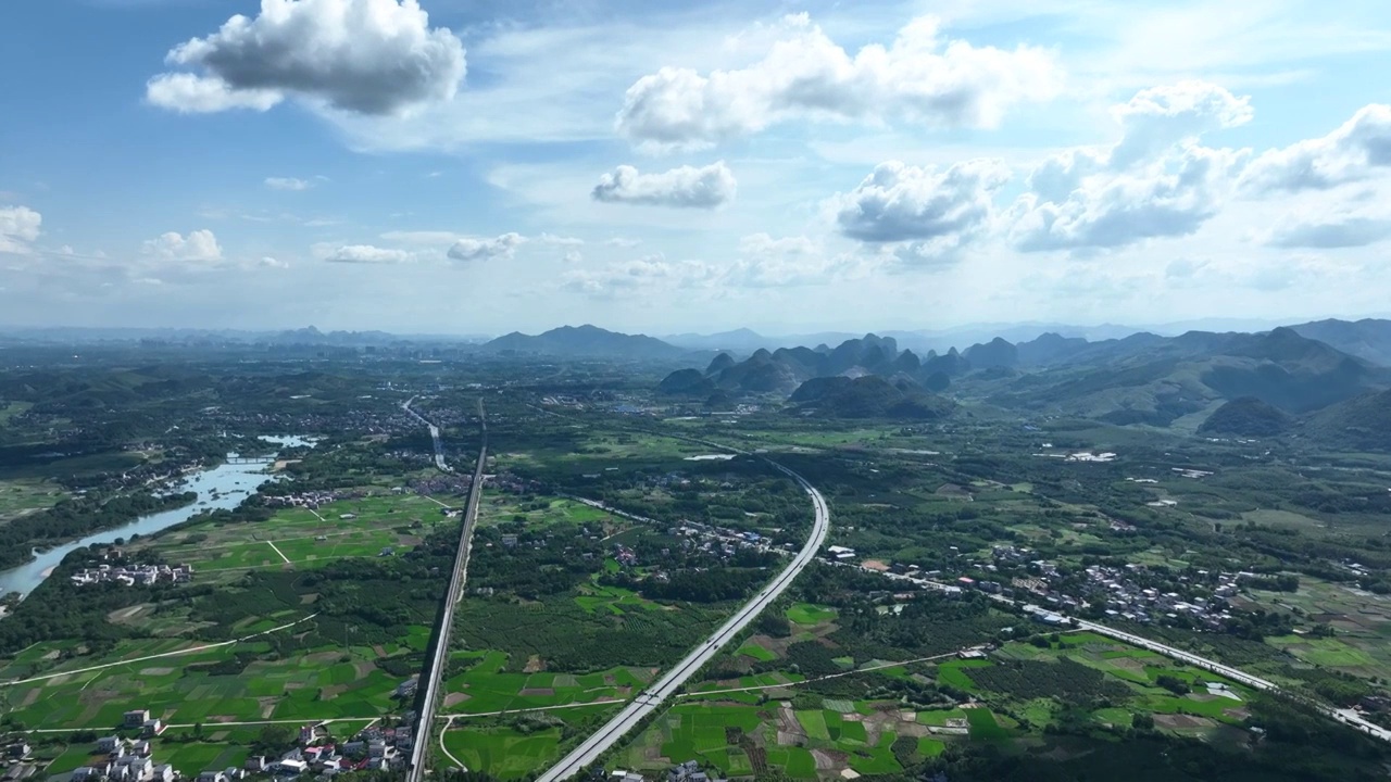 蓝天白云阳光下穿过山间田园的高速公路视频素材