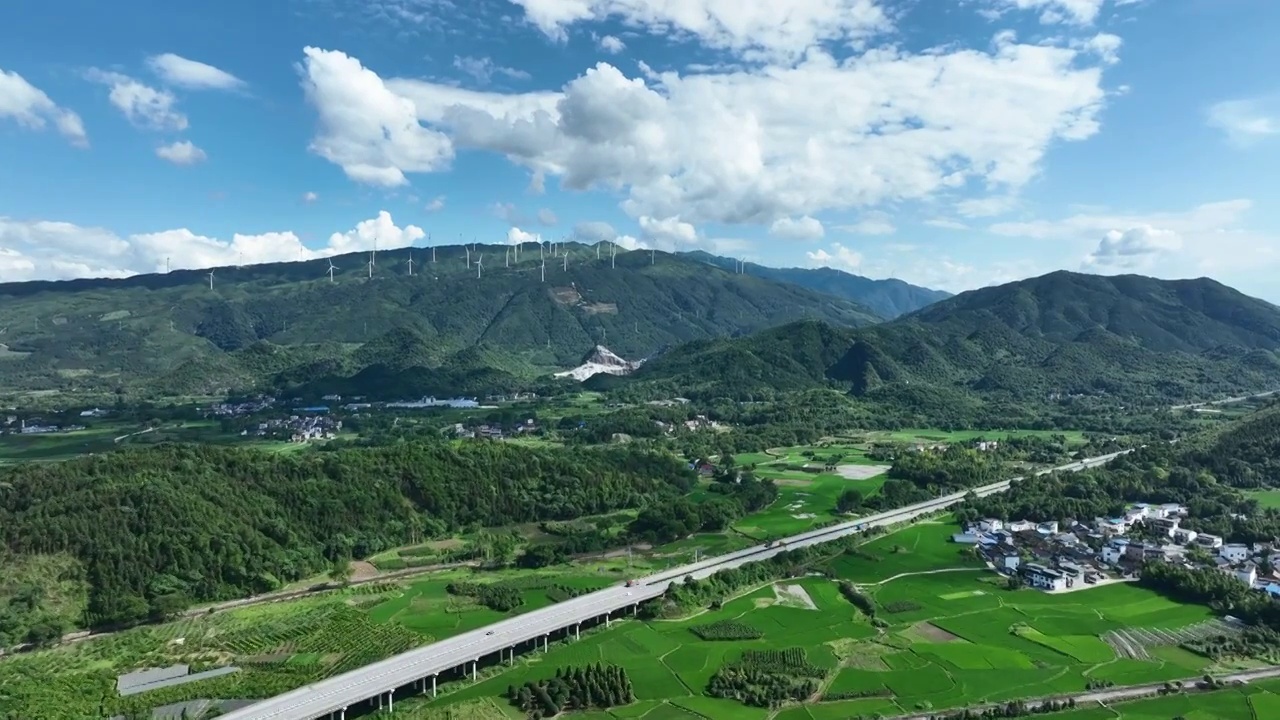 蓝天白云阳光下穿过山间田园的高速公路视频素材