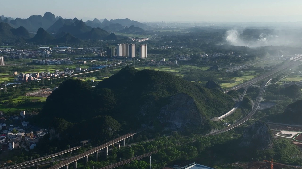 阳光下穿过城市边缘山体隧道的列车视频素材