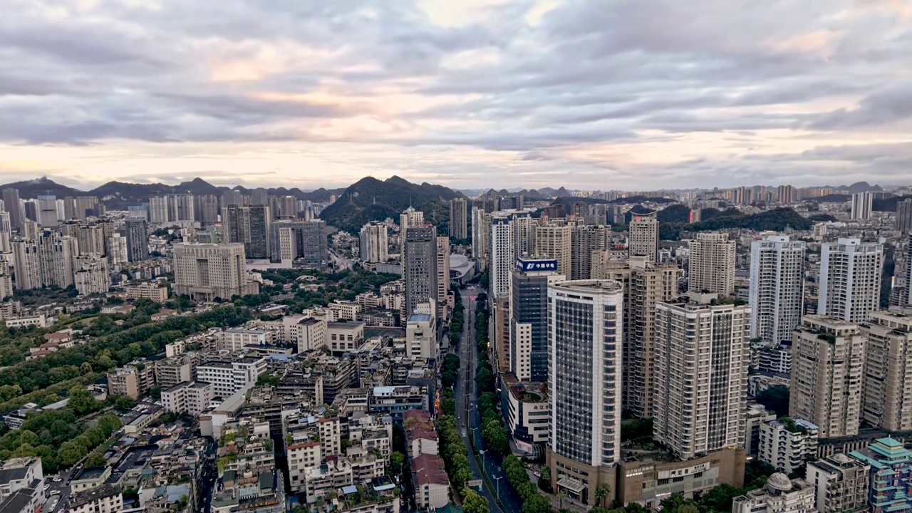 中国贵州省贵阳市观山湖区夕阳映照下核心商务区CBD蓝天白云下的城市风光固定机位延时摄影视频素材