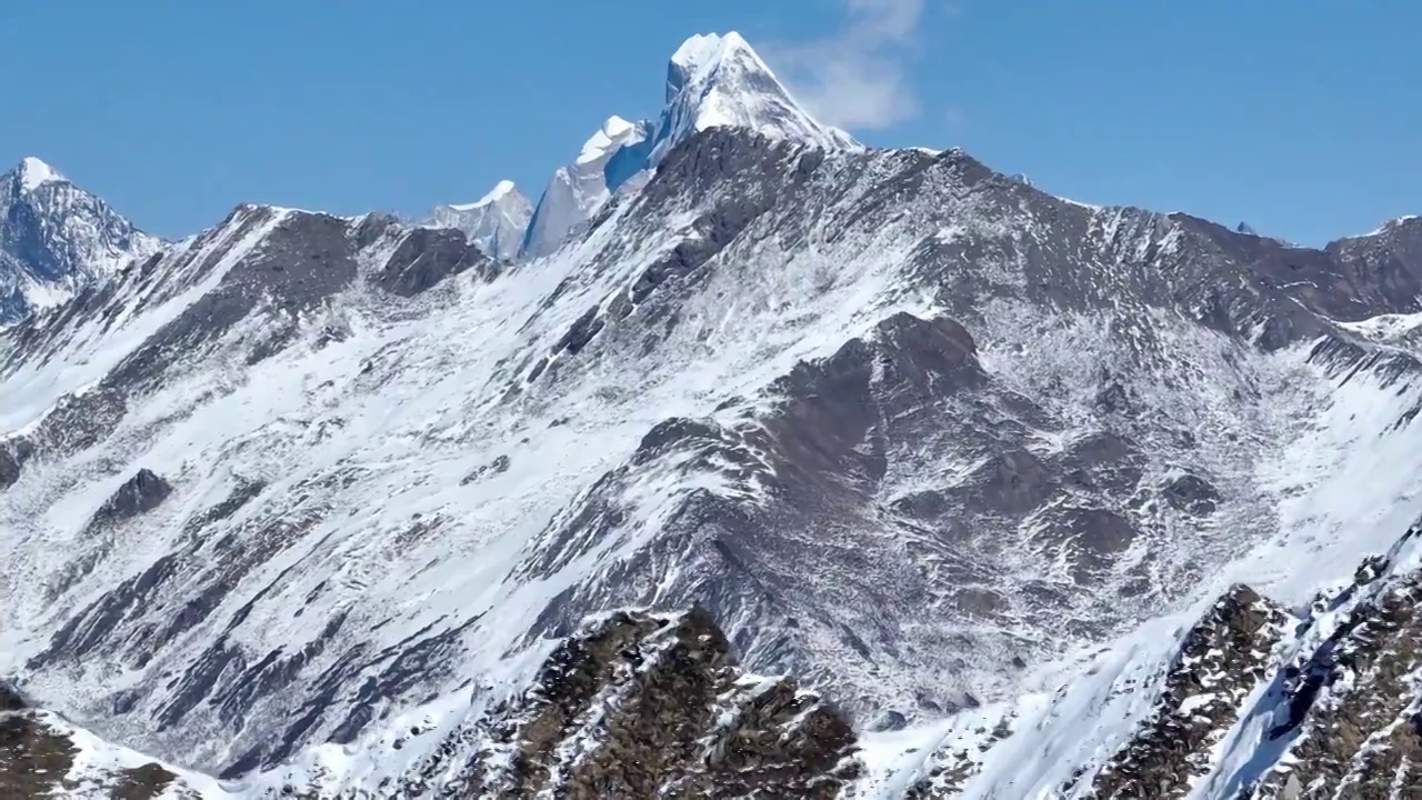 透过雪山夹金山山脊航拍四姑娘山幺妹峰风景视频素材