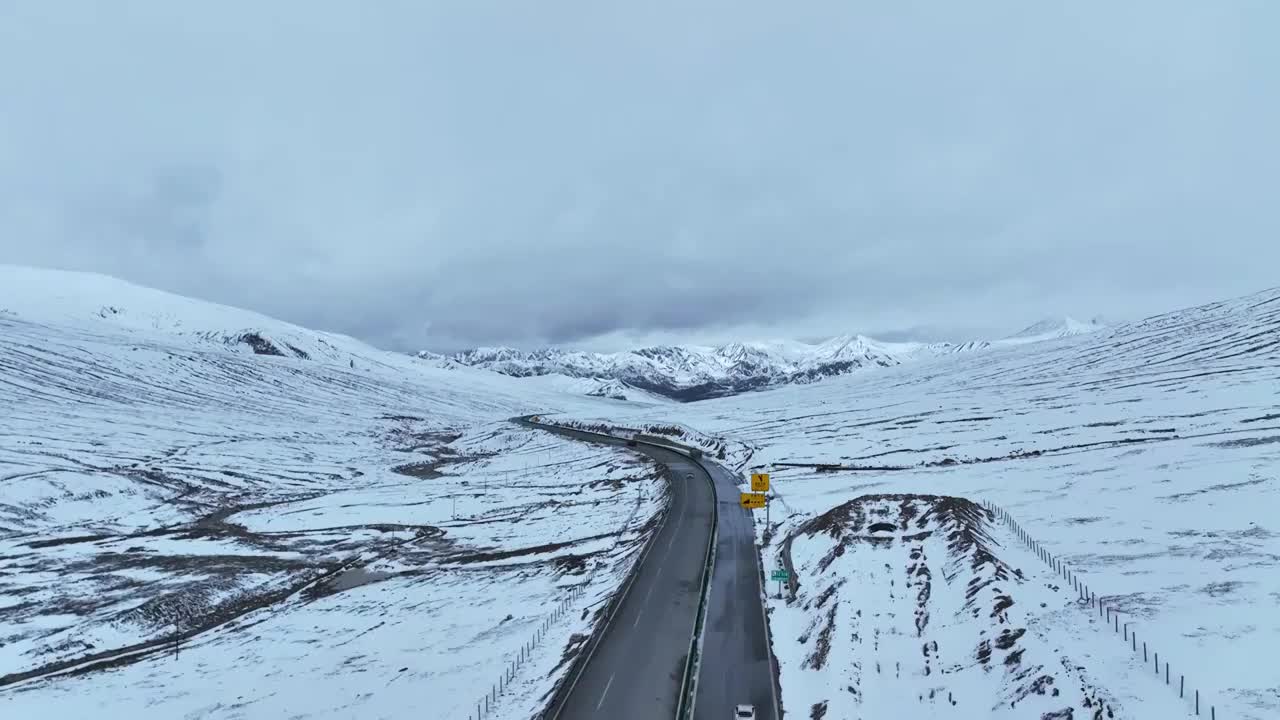 航拍青海果洛阿尼玛卿雪山与高速道路视频素材