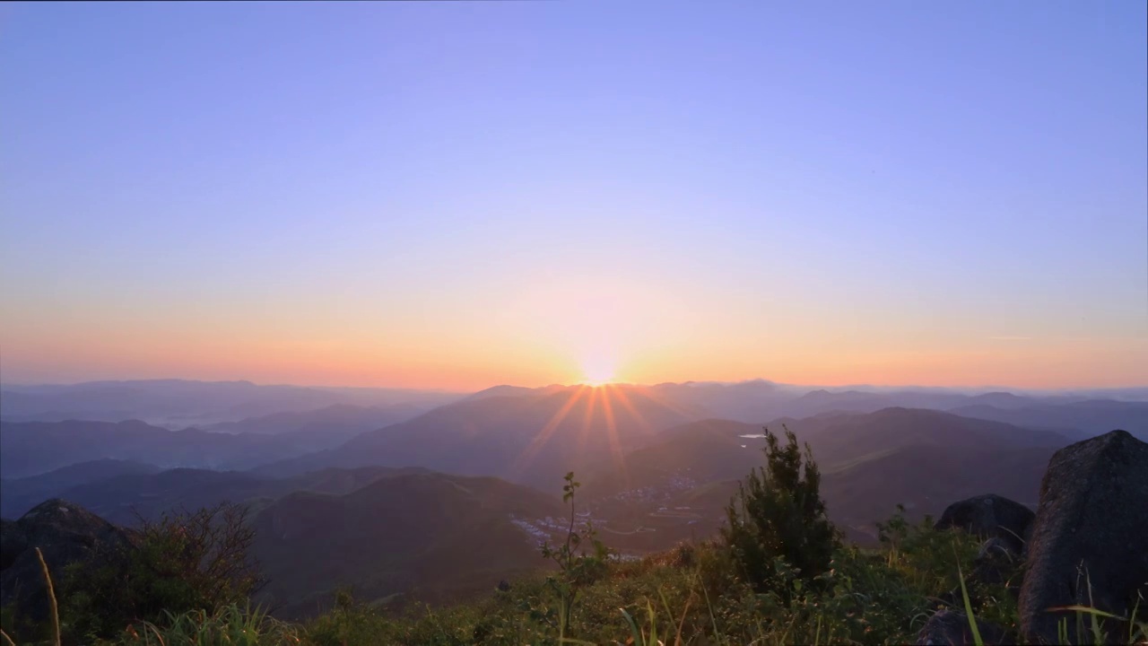 广角拍摄晴空浙江省绍兴市上虞区覆卮山度假村景区日出时分太阳从山顶升起的横屏画面延时视频素材