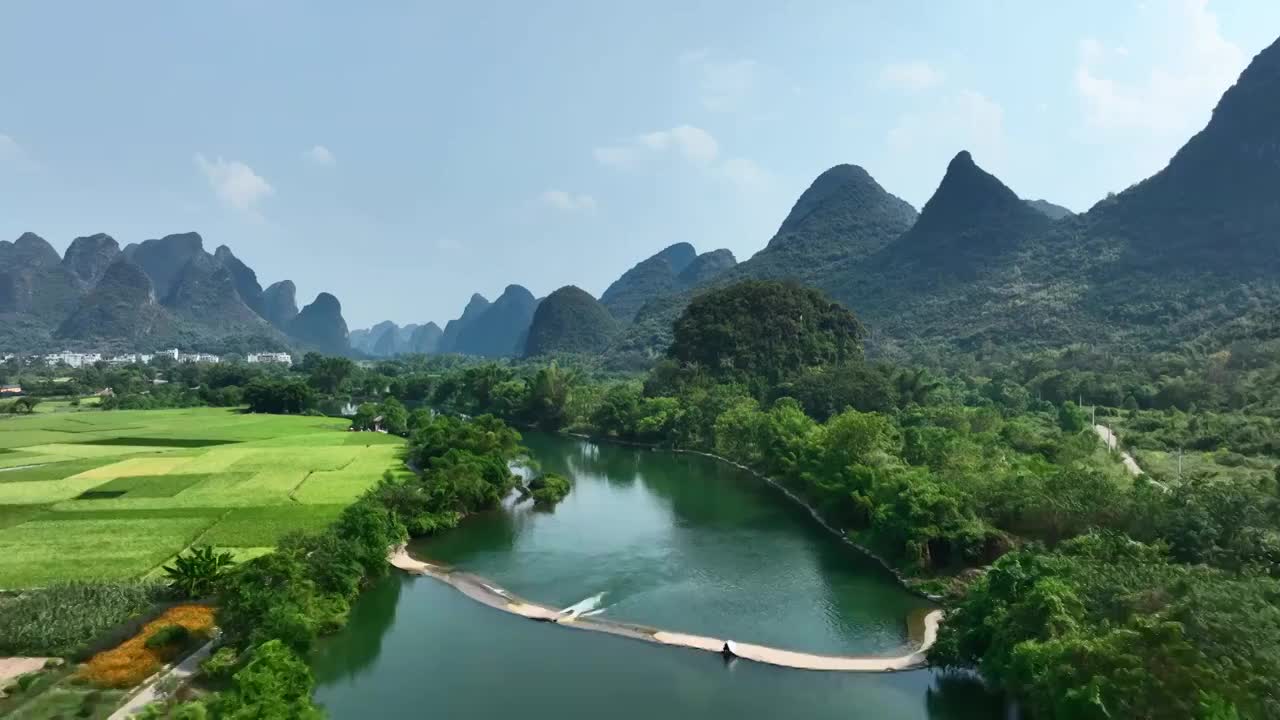 秋天阳光下阳朔遇龙河上漂流的竹筏和两岸的田园风光视频素材