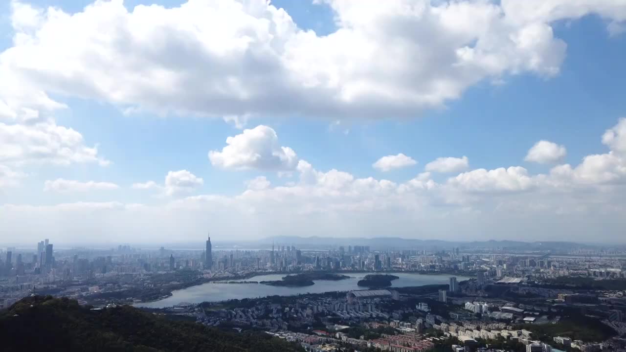 晴朗多云天气紫金山山顶看玄武湖，南京城市天际线风光延时视频素材