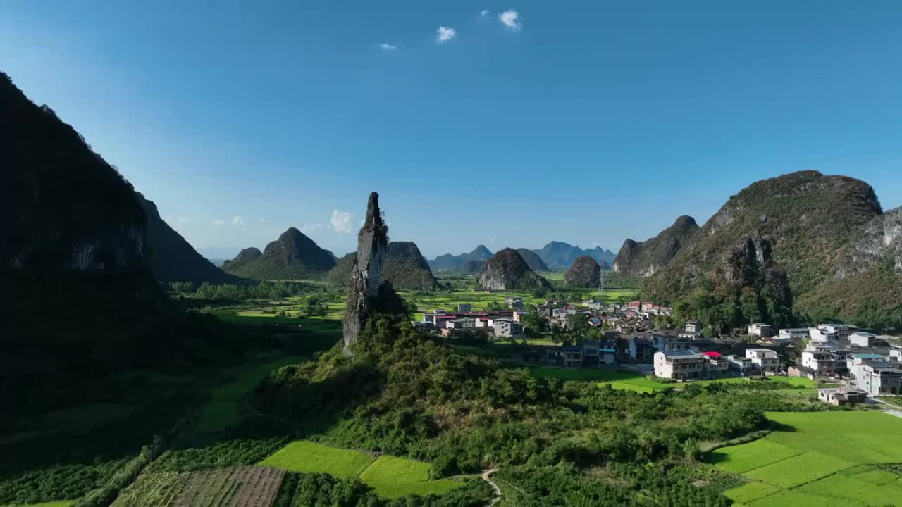 秋天山谷中伫立的石山和周围的村庄稻田视频素材