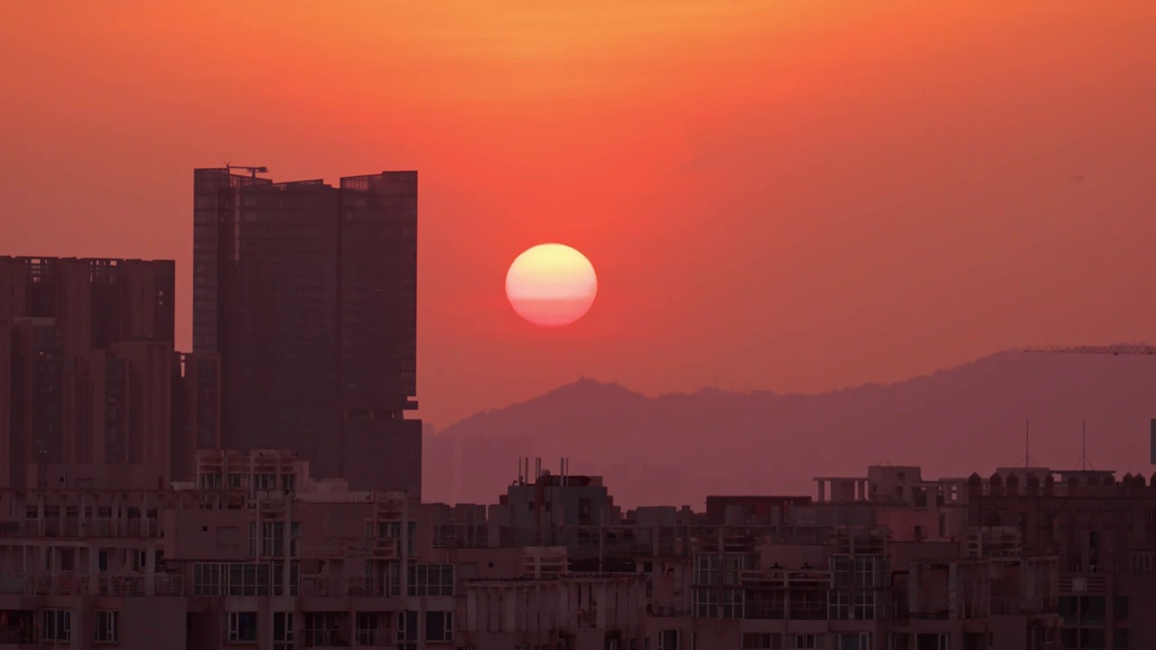 太阳在建筑和山脉中落下延时视频素材