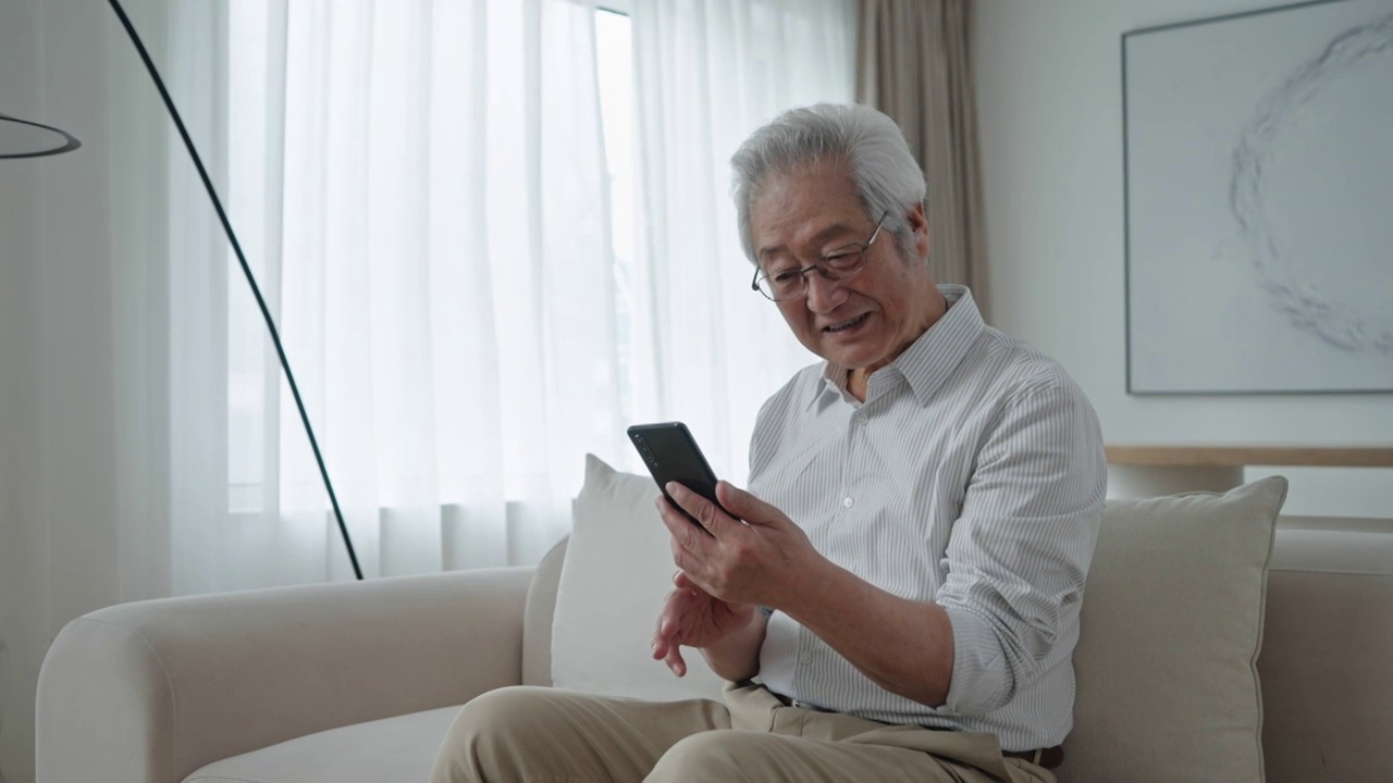 老年男子在家用手机视频聊天视频素材