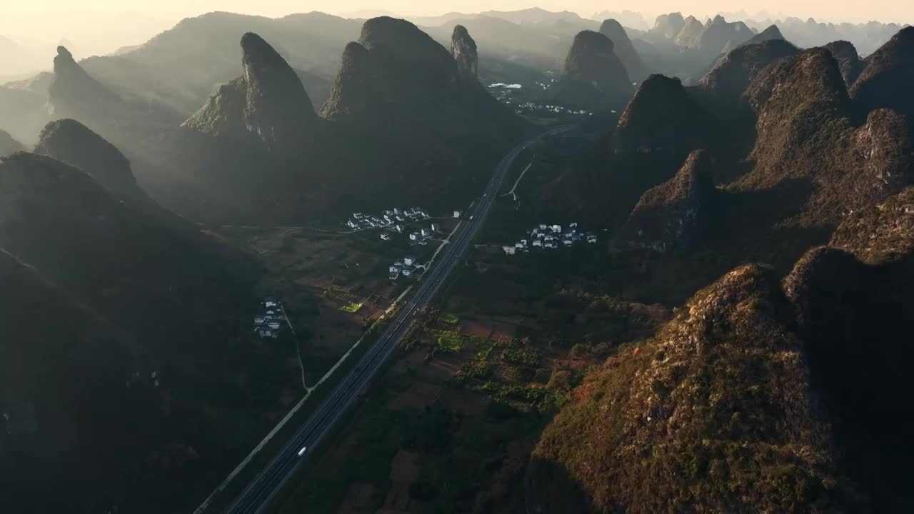 秋天夕阳在山峰中形成的射光和山谷中的高速公路视频素材