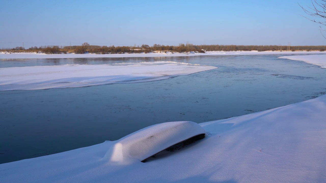 冬天雪后岸边的小船和河流里的冰排视频素材