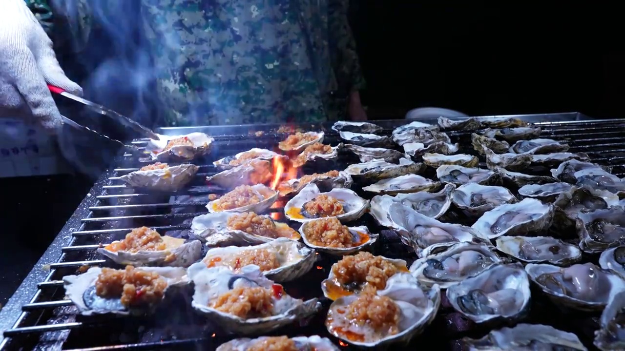 慢镜头升格拍摄城市街头美食海鲜烧烤烹饪生蚝视频素材