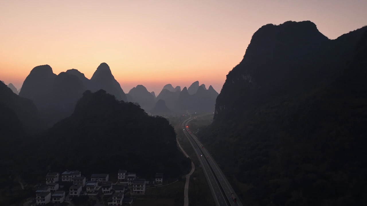 黎明日出时分在喀斯特地貌峡谷中穿行的高速公路视频素材