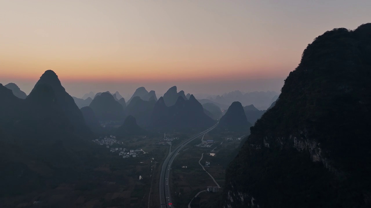 黎明日出时分在喀斯特地貌峡谷中穿行的高速公路视频素材