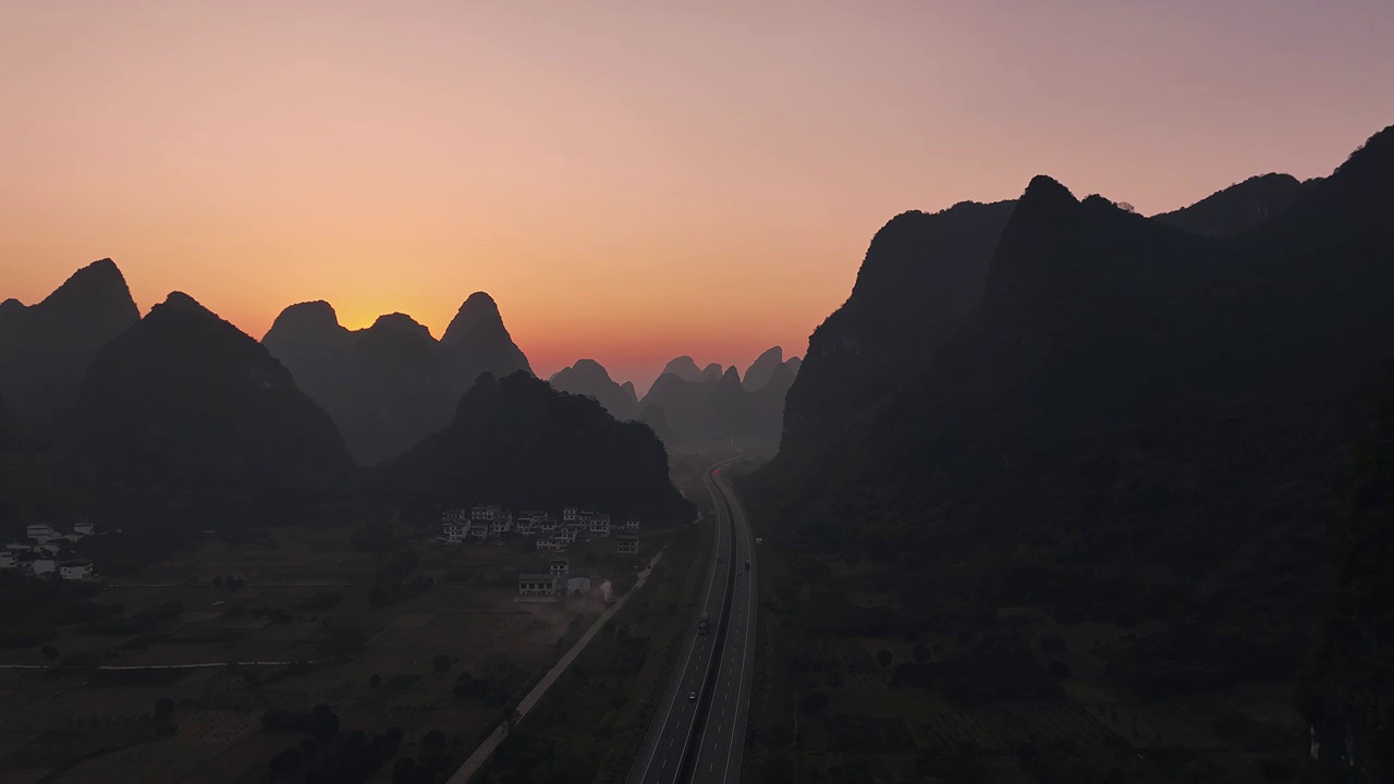 黎明日出时分在喀斯特地貌峡谷中穿行的高速公路视频素材