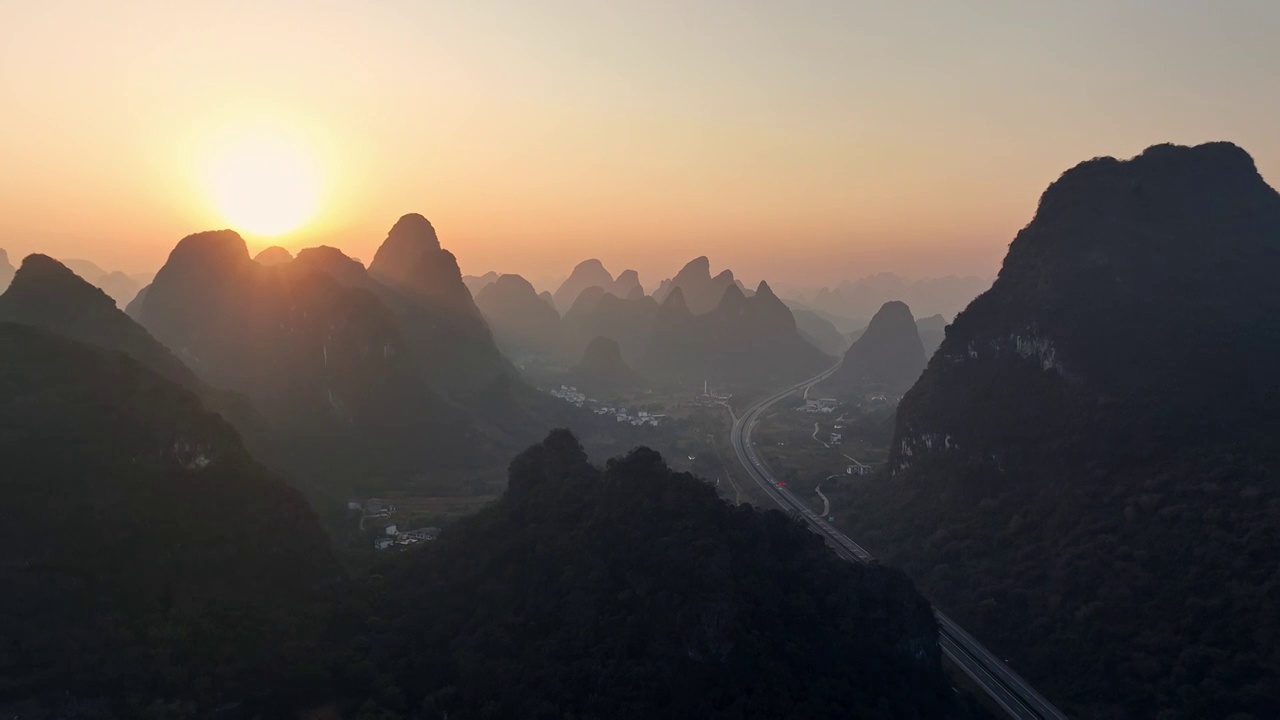 黎明日出时分在喀斯特地貌峡谷中穿行的高速公路视频素材