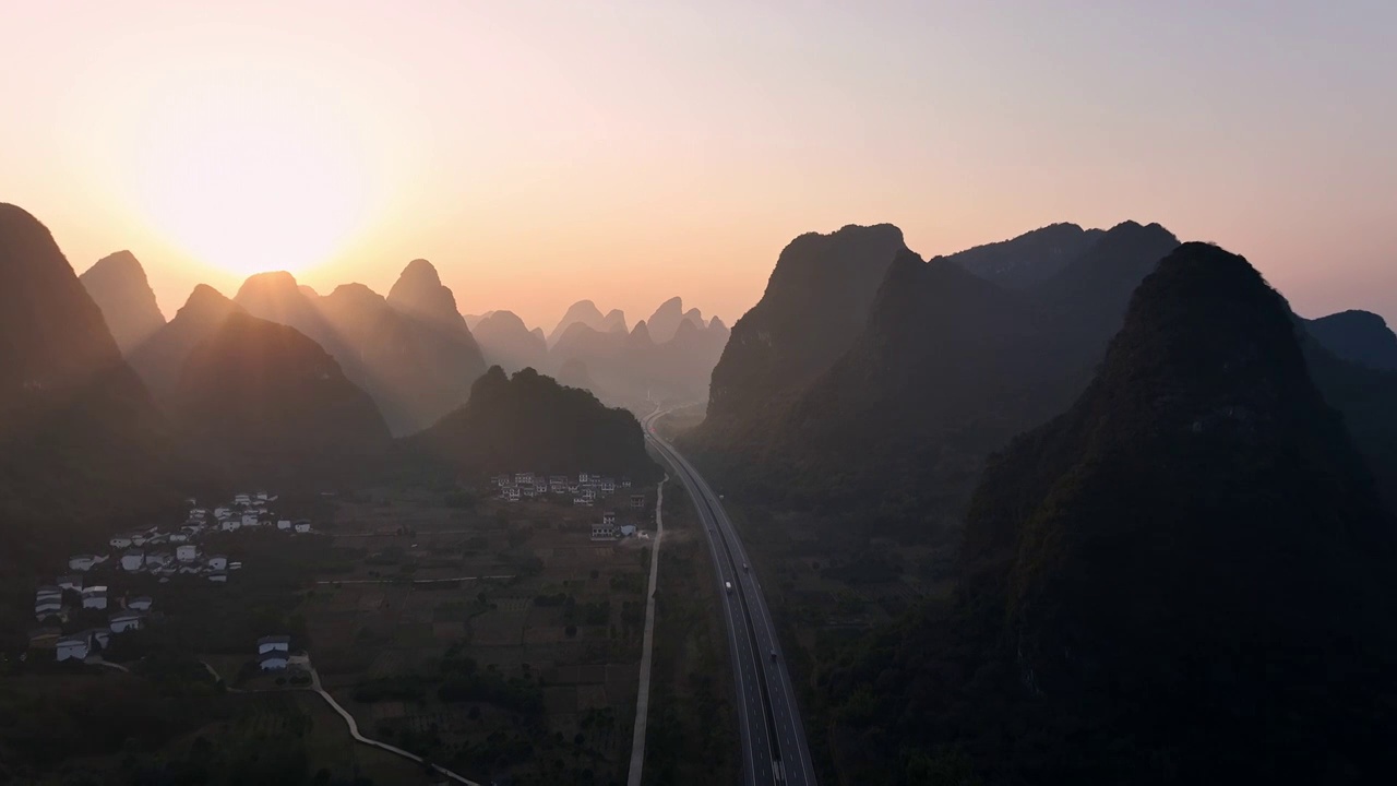 黎明日出时分在喀斯特地貌峡谷中穿行的高速公路视频素材