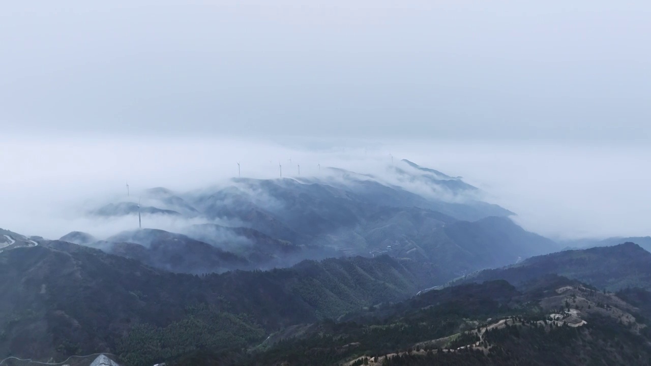 清晨高海拔山顶上的风力发电风车和山谷中涌动的云雾视频素材