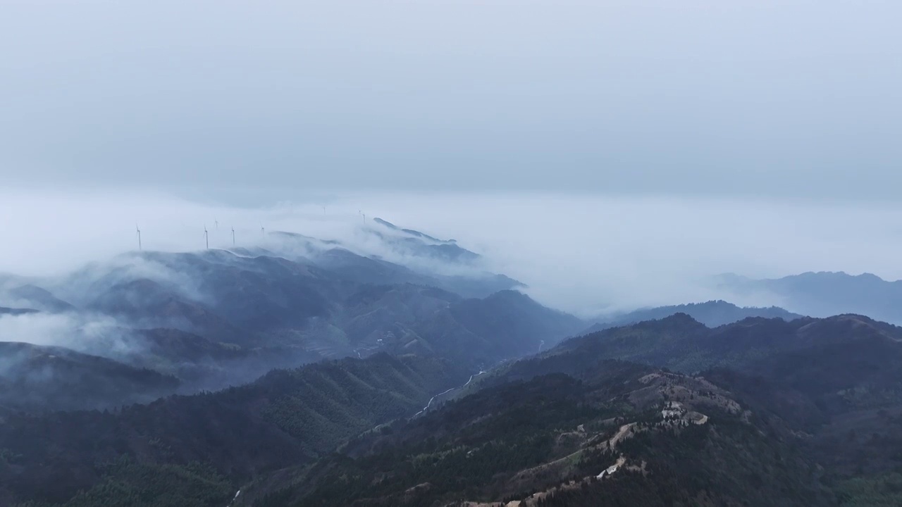 清晨高海拔山顶上的风力发电风车和山谷中涌动的云雾视频素材