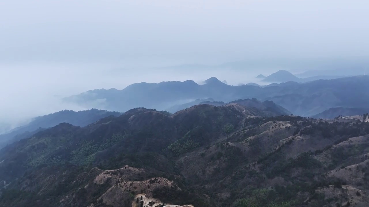 清晨高海拔山顶上的风力发电风车和山谷中涌动的云雾视频素材