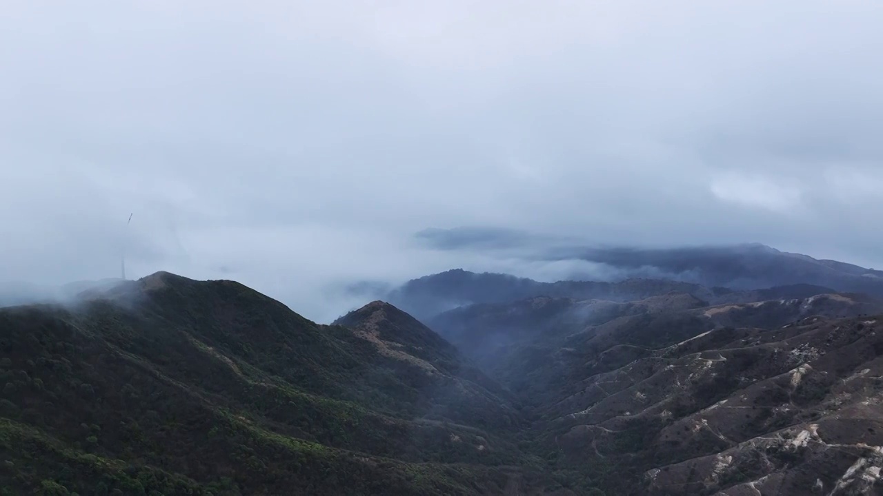 清晨高海拔山顶上的风力发电风车和山谷中涌动的云雾视频素材