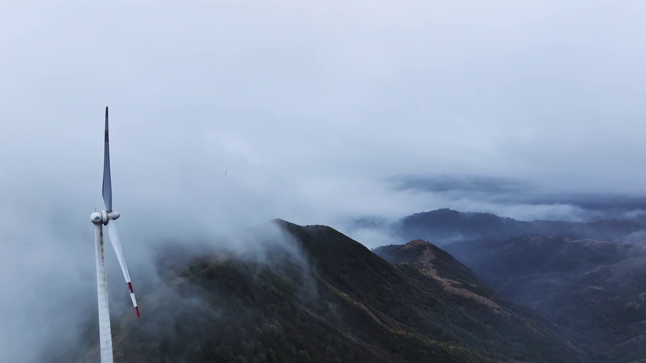 清晨高海拔山顶上的风力发电风车和山谷中涌动的云雾视频素材