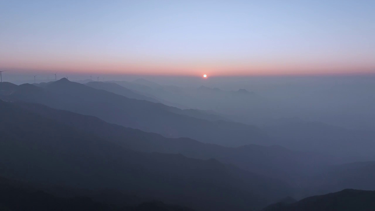 夕阳暮色中高海拔山顶的风力发电风车和山谷中涌动的云雾视频素材