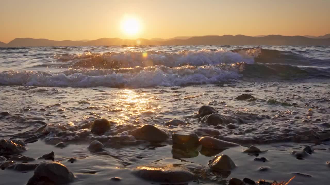 云南玉溪抚仙湖的日落水面浪花唯美空镜视频素材