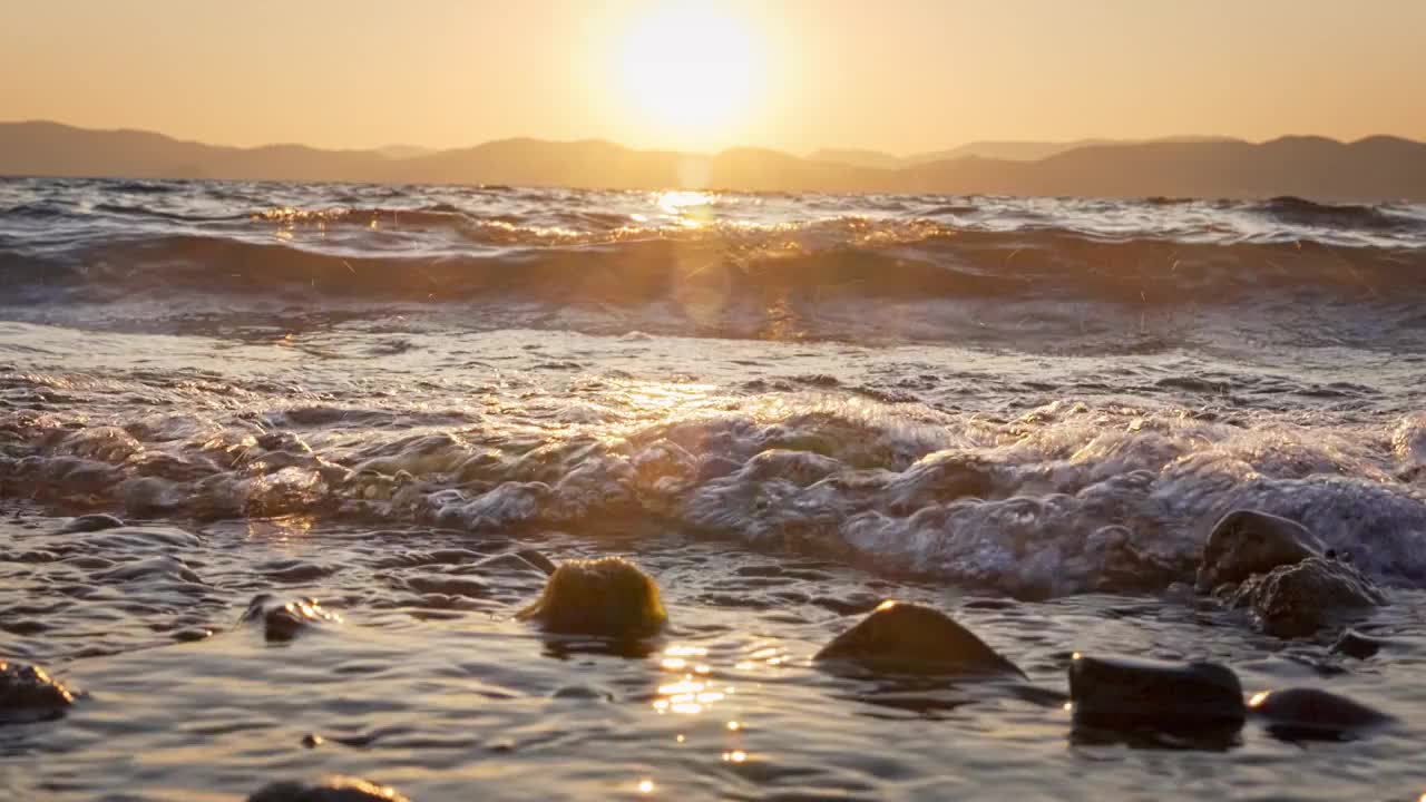 云南玉溪抚仙湖的日落水面浪花唯美空镜视频素材