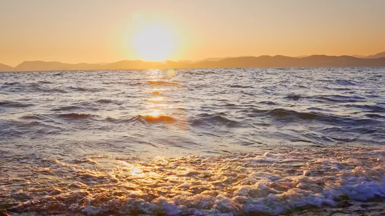 云南玉溪抚仙湖的日落水面浪花唯美空镜视频素材