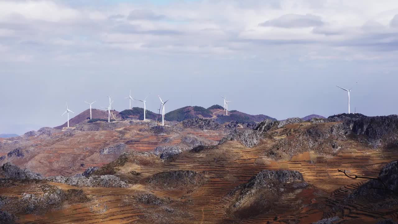 云南红土地丘陵上的风力发电大风车视频素材