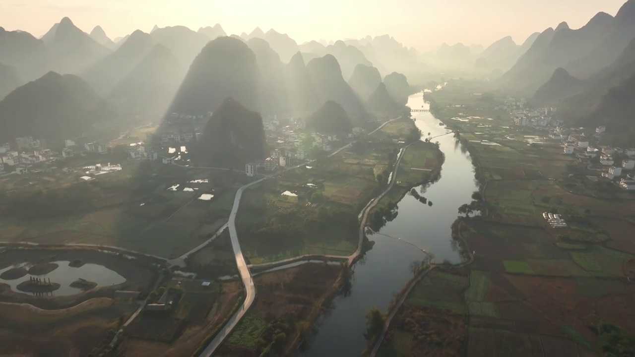 早晨初升的阳光照在阳朔遇龙河岸边的山峰和水面上视频下载