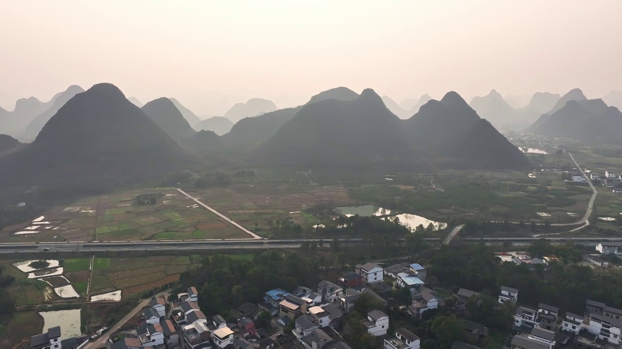 傍晚落日余晖下穿过山间田园的高速公路视频素材