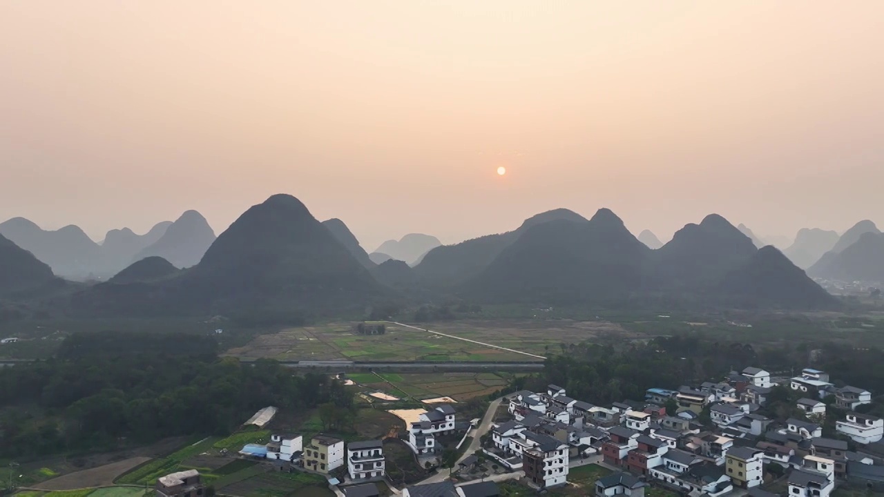 傍晚落日余晖下穿过山间田园的高速公路视频素材