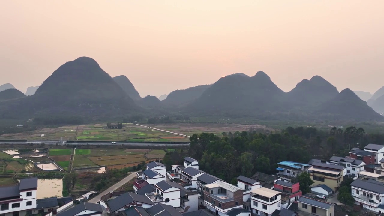 傍晚落日余晖下穿过山间田园的高速公路视频素材