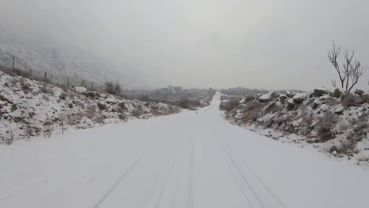 车辆行驶在正在下雪的山边公路上视频素材