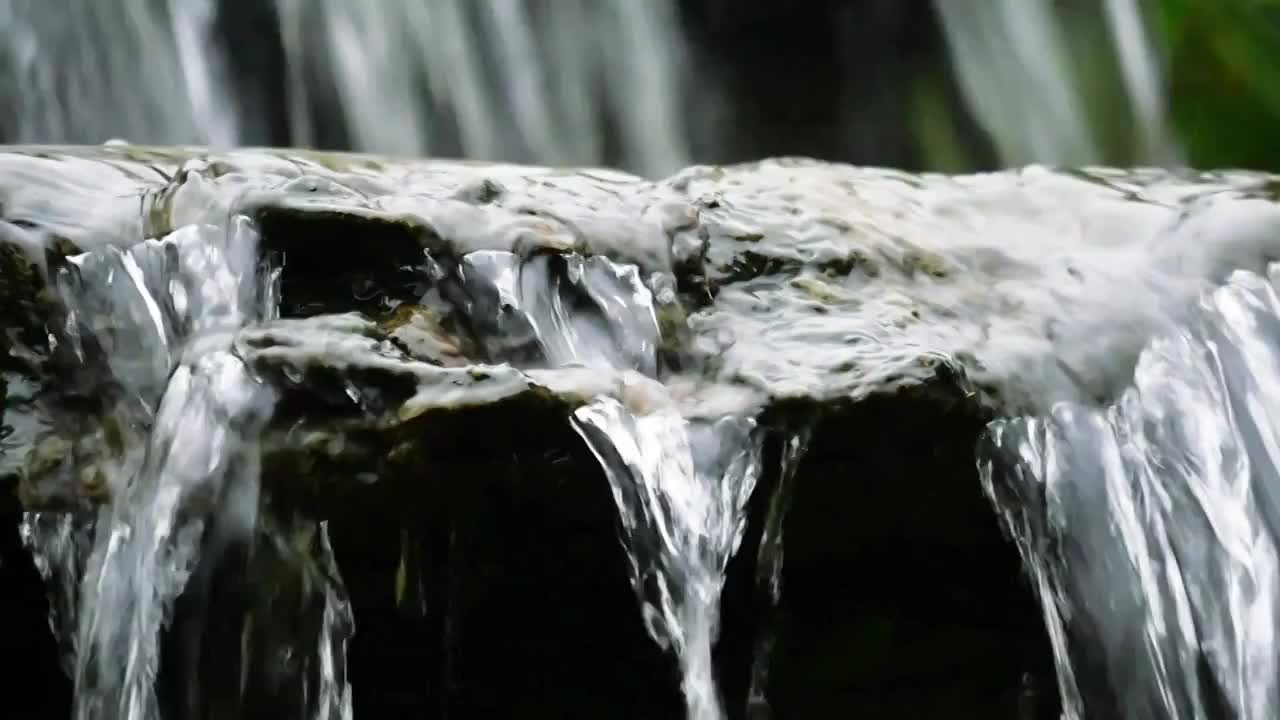 早春清明时节雨水汇成清澈溪水山涧慢慢流淌潺潺打磨着光滑岩石跳跃成泉水和瀑布晶莹透明瀑布视频空镜素材视频素材