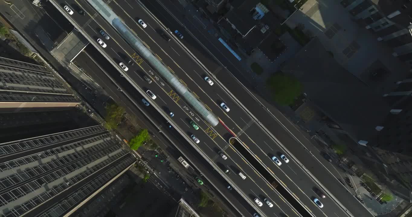 旋转俯拍城市高楼下街道路密集汽车行驶车流视频素材