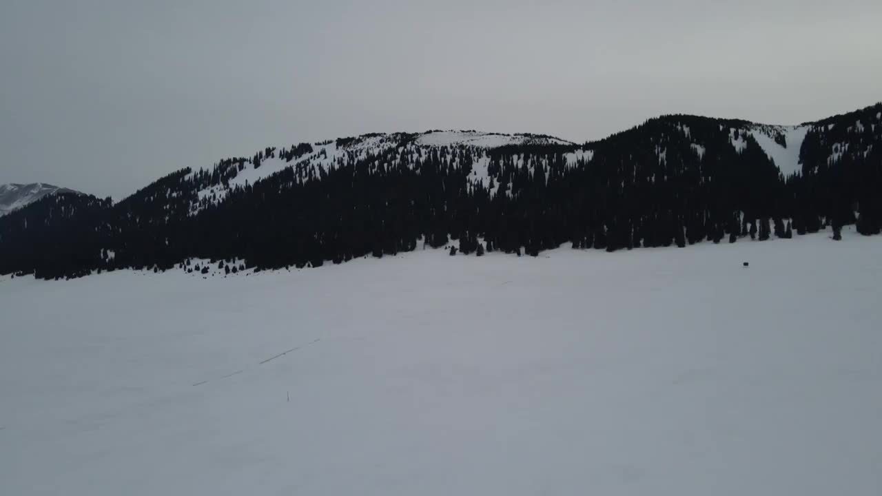 航拍冬季傍晚雪后的中国新疆赛里木湖群山视频素材