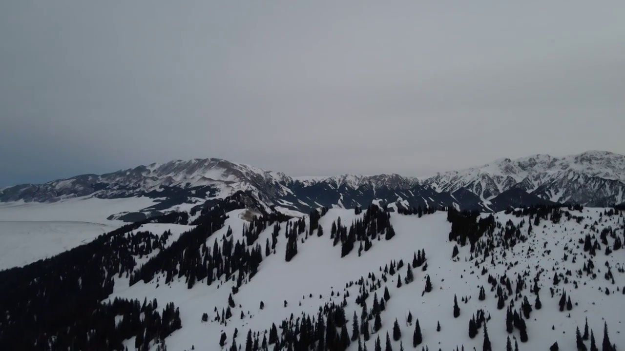 航拍冬季傍晚雪后的中国新疆赛里木湖群山视频素材