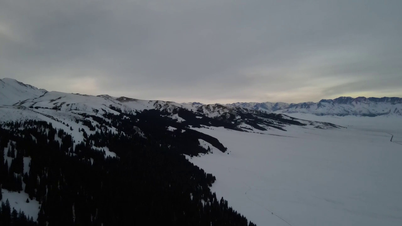 航拍冬季傍晚雪后的中国新疆赛里木湖群山视频素材