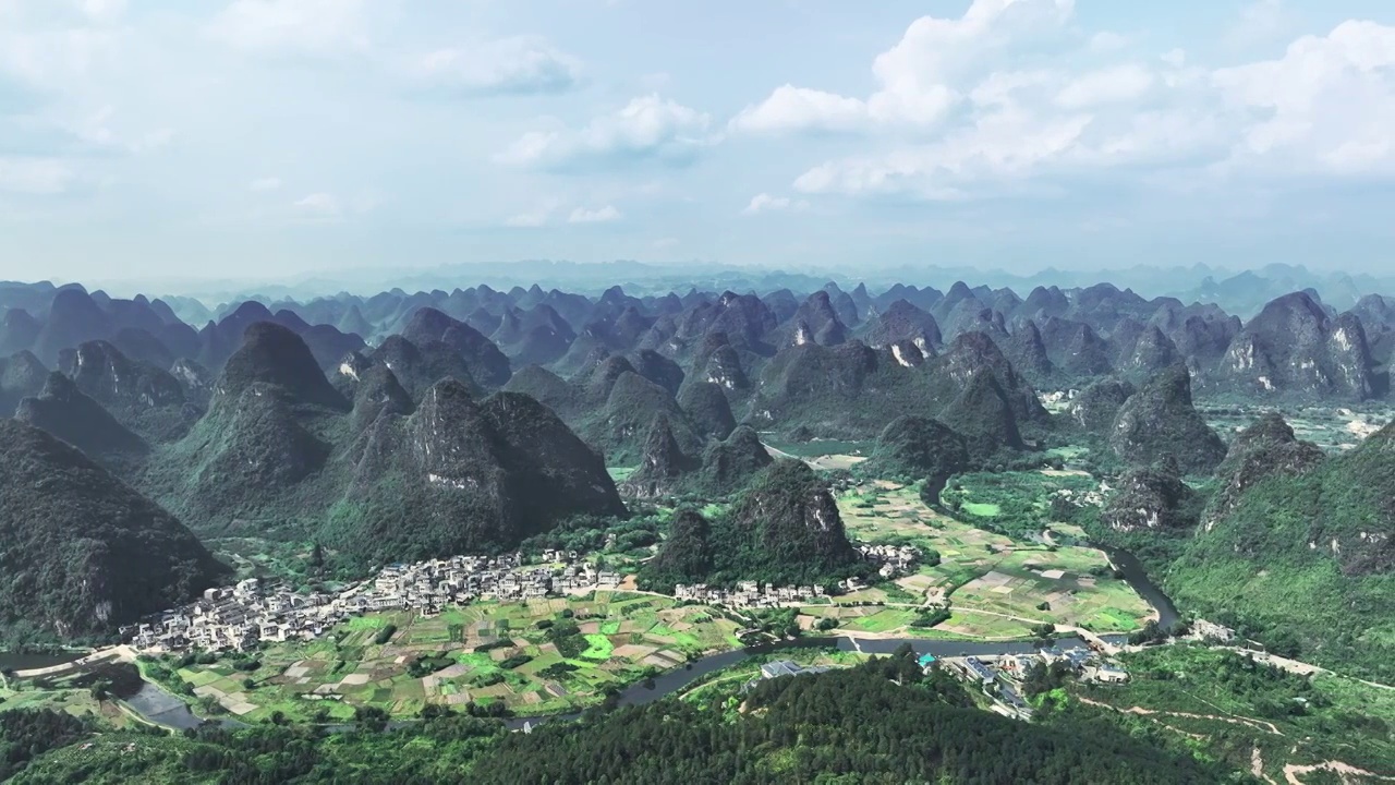 春天蓝天白云阳光下阳朔喀斯特地貌山谷中遇龙河两岸的田园风光视频素材