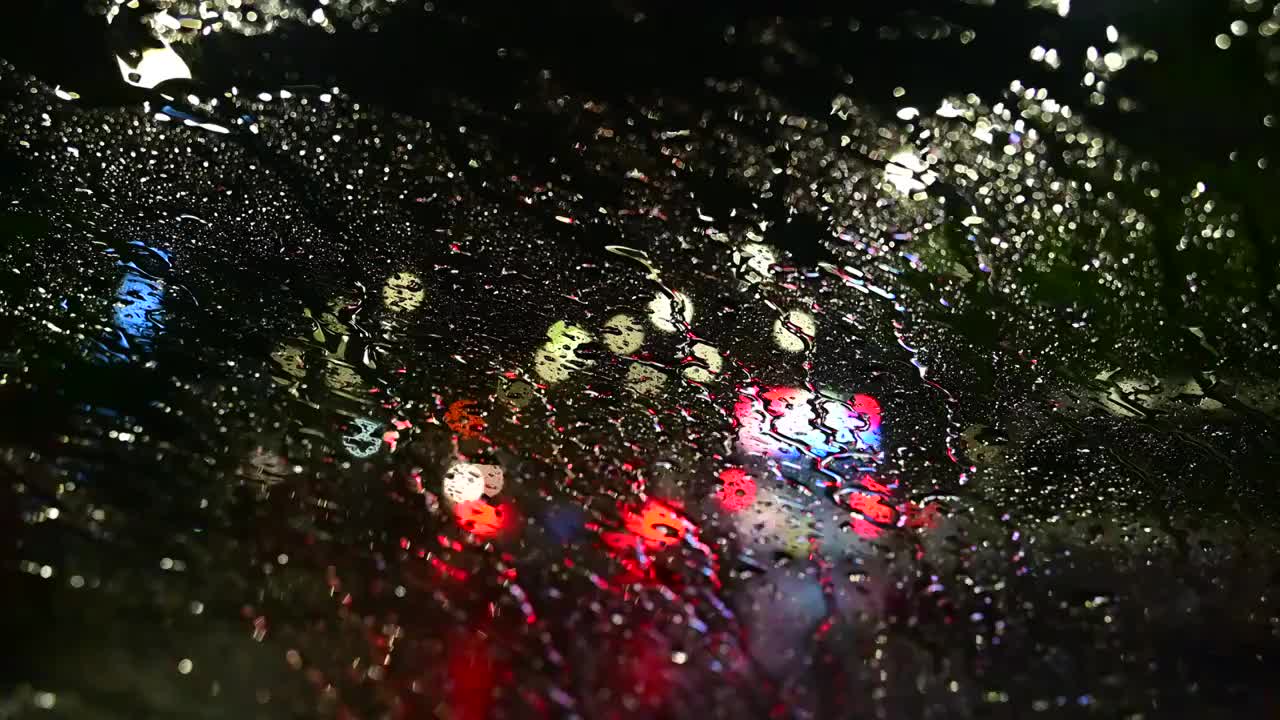 暴雨中的车窗玻璃与城市夜景光斑视频素材